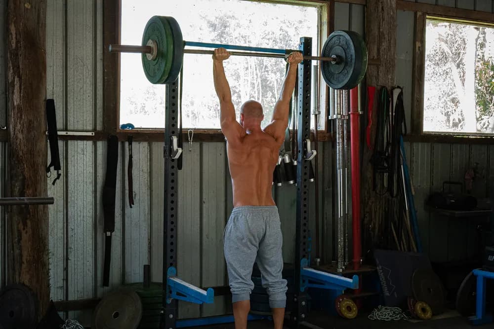 Coach performing an overhead press