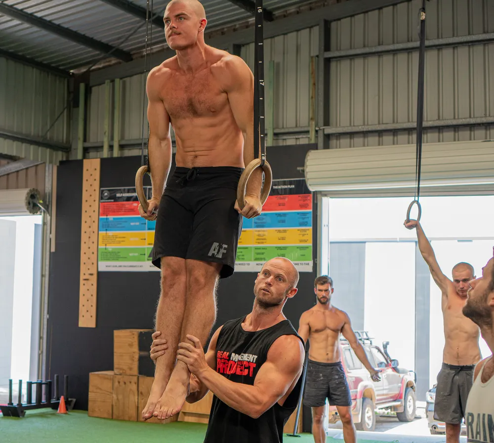 Coach spotting an athlete on gymnastics rings